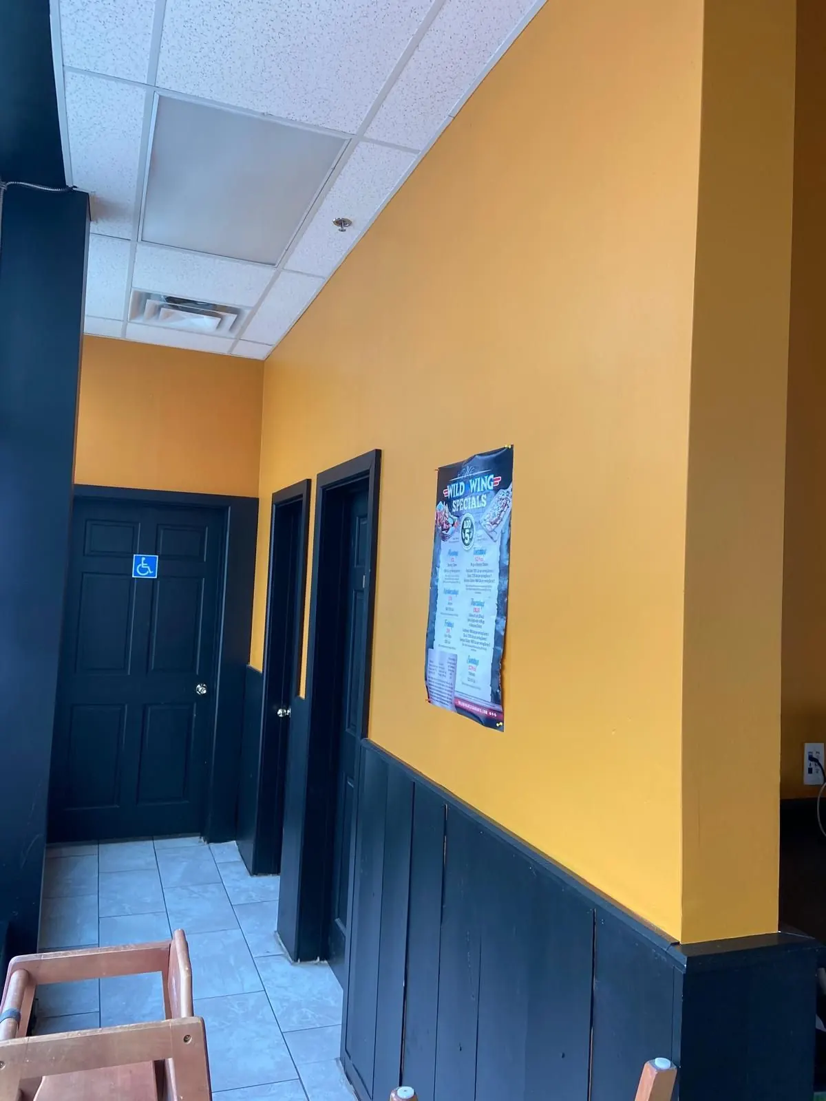 Restaurant hallway painted yellow with black trim